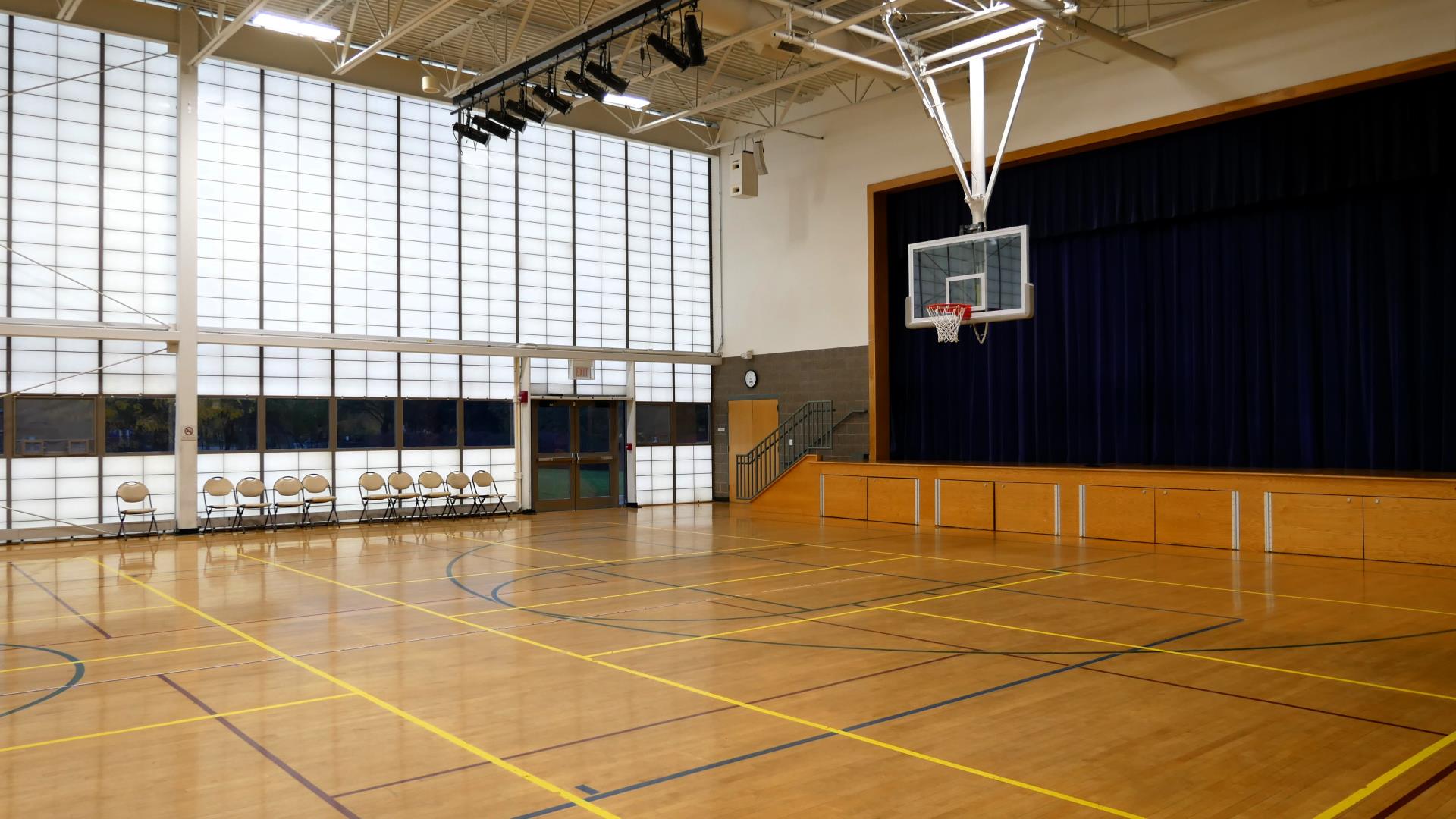 Levy gym with basketball hoop and stage in the background