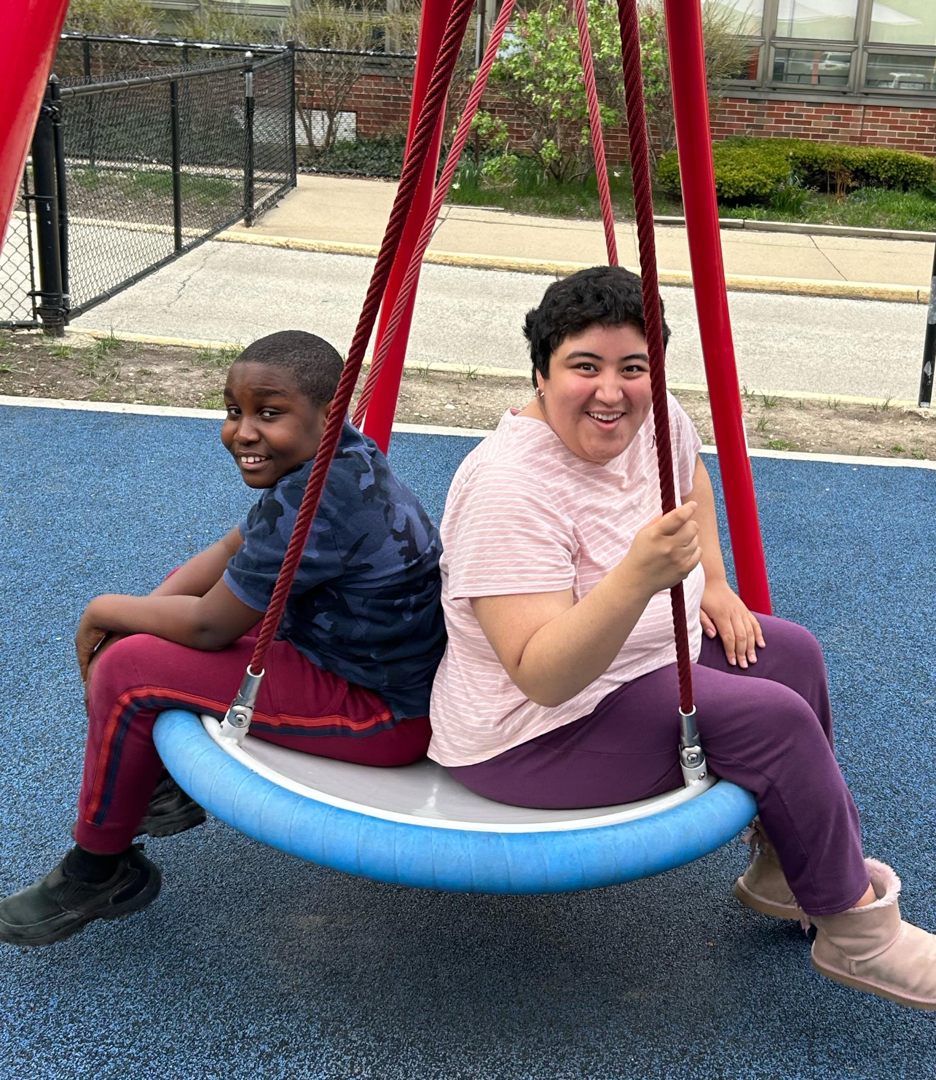 Two children on a swing in a park